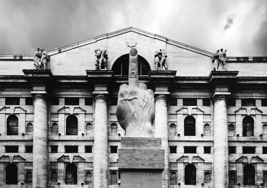 “L.O.V.E.” by Maurizio Cattelan placed in Piazza Affari in Milan. Palazzo Mezzanotte, the stock exchange headquarters, is a hallmark of Fascist architecture. As it’s placed, it points away from the stock exchange, and not at it.”